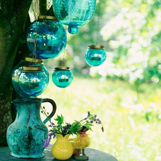 Glass lanterns    Light up your garden with tree-hung glass lanterns. Choose colours to match your other garden accessories, like these turqouise and yellow jugs. Jam jars with wire handles make fun, budget lanterns, and are a fun craft project for older children.