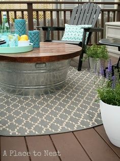 bucket table for the deck. this is a genius idea. you can store all the stuff in the table that you don’t want to leave out in case it rains (citronella candles, pillows, etc.), then just grab it out…