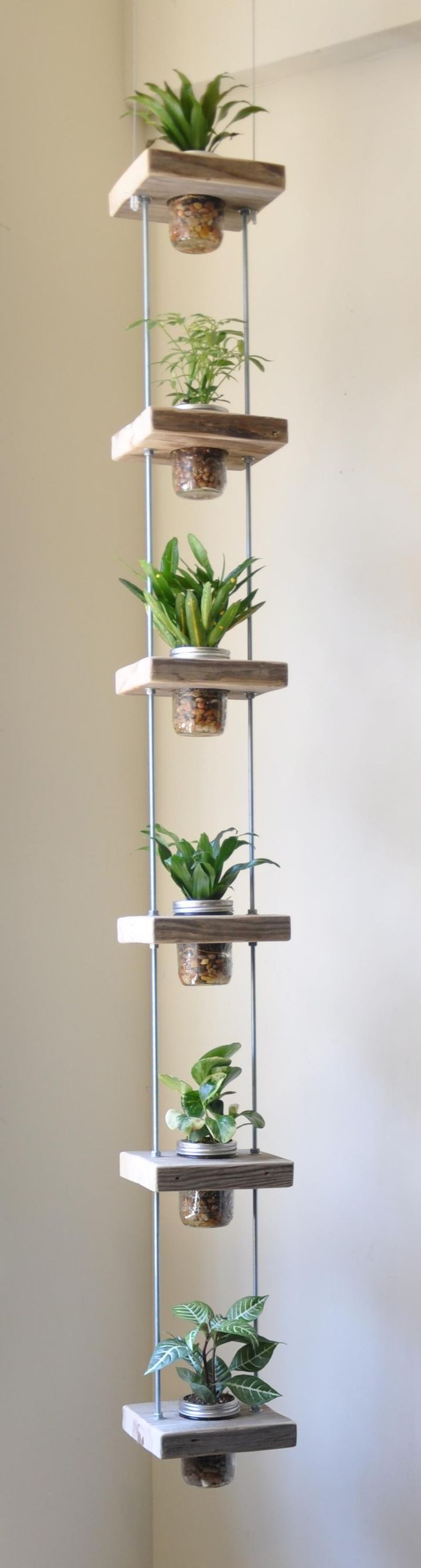Don’t have much space to grow your   favorite plants? Try building a vertical   garden like this one, designed by Susie   Frazier. Using salvaged wood, threaded   rods and bolts, and a handful of mason   jars, you can construct a simple hanging   planter to add a lot of green to your   game. See original article for instructions.