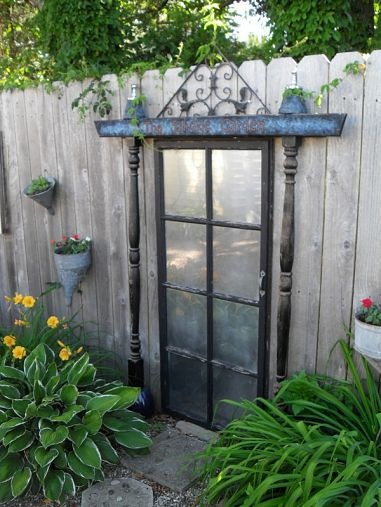 Garden Salvage – Secret door to no where – old door mirrored and mounted to the fence