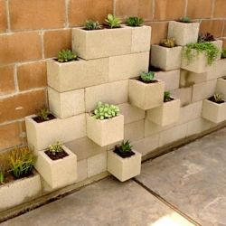 I totally want this in my garden! its a planter made of cinderblocks stacked against the wall in a very unique way.
