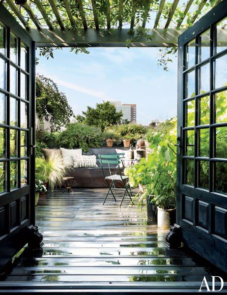 A rooftop garden in New York City is outfitted with French doors and bistro chairs.