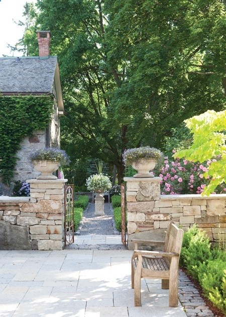 Rustic Country Pathway Stone elements and lush plants give a garden an old-world quality. Section off your backyard into separate areas by creating a low-level stone wall complete with an aged garden gate. Place planters atop pillars for added height. For continuity, frame the pathway extending past the gate with the same stone used in the enclosed area.