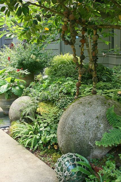 Concrete balls nestled in shade garden… in the PNW and other wet areas, these will soon turn into moss balls!