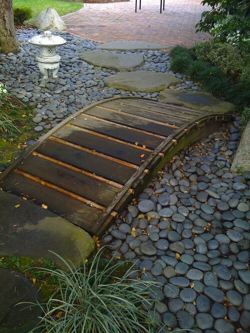 Small wooden bridge over a dry river bed.