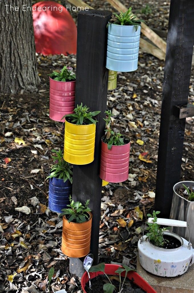 Coffee Cans painted and hung on a post.these would be great in my flower beds with ferns, impatients or hostas