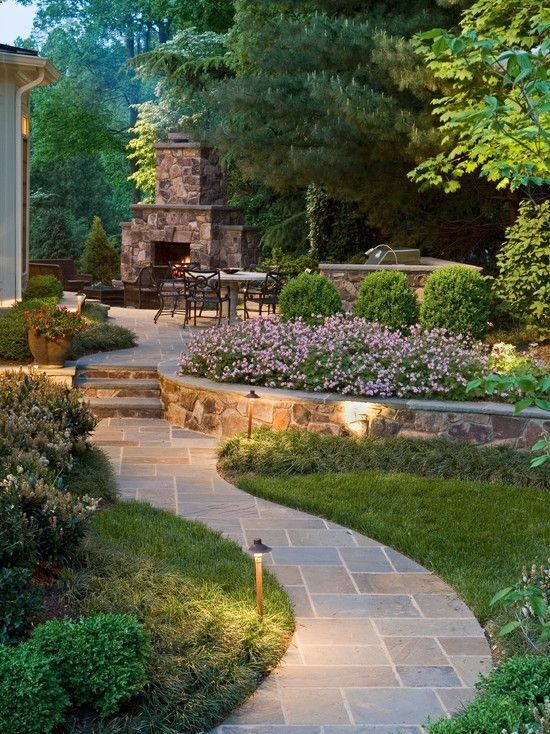 Perfect back yard for the family and friends. Very well done back yard with curved stone walk, short stone retaining wall for the raised planting flower bed, lovely green plantings and accent lighting, leading up to the patio.