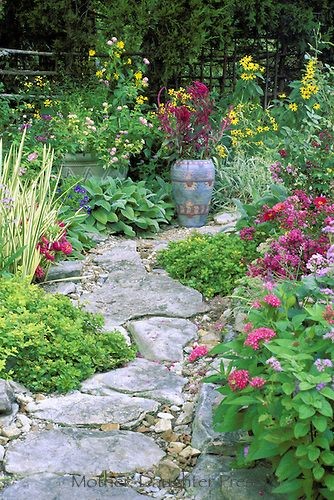 Beautiful backyard ~ Rock pathway curves through a garden of mult-colored blooms and herbs with painted Mexican ceramic pot ~ landscaping ideas