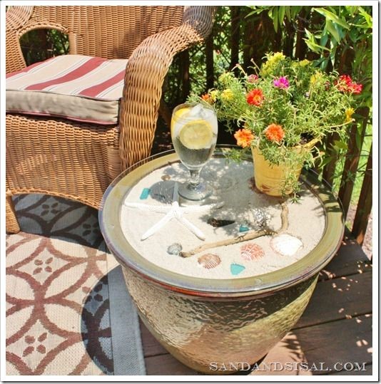 take a planters Pot/garden pot fill with sand and seashells and buy a glass table top and there you go DIY deck/patio table